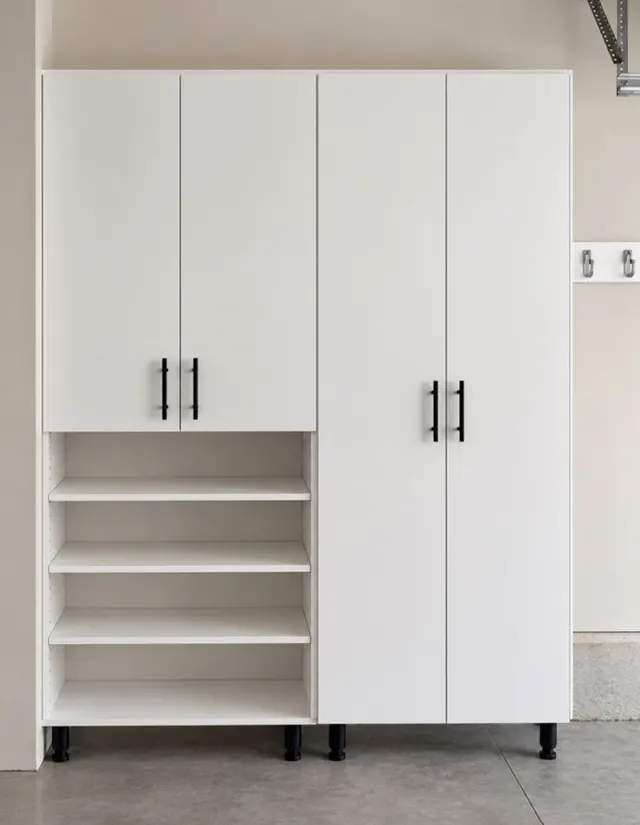 White garage cabinet with tall doors and open adjustable shelves on black legs, on a concrete floor