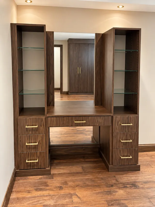 Walnut vanity desk with a center mirror, glass-shelf towers and drawers with brass pulls