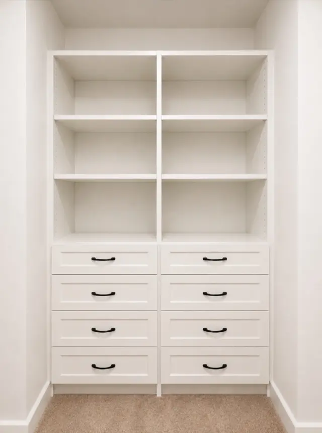 White linen shelving above a bank of drawers with black pulls