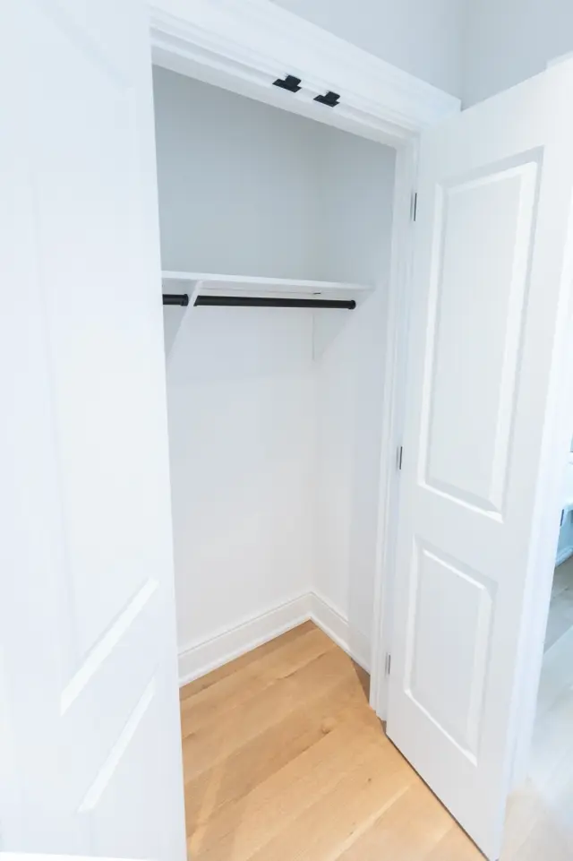 Single-door closet with a white shelf and hanging rod