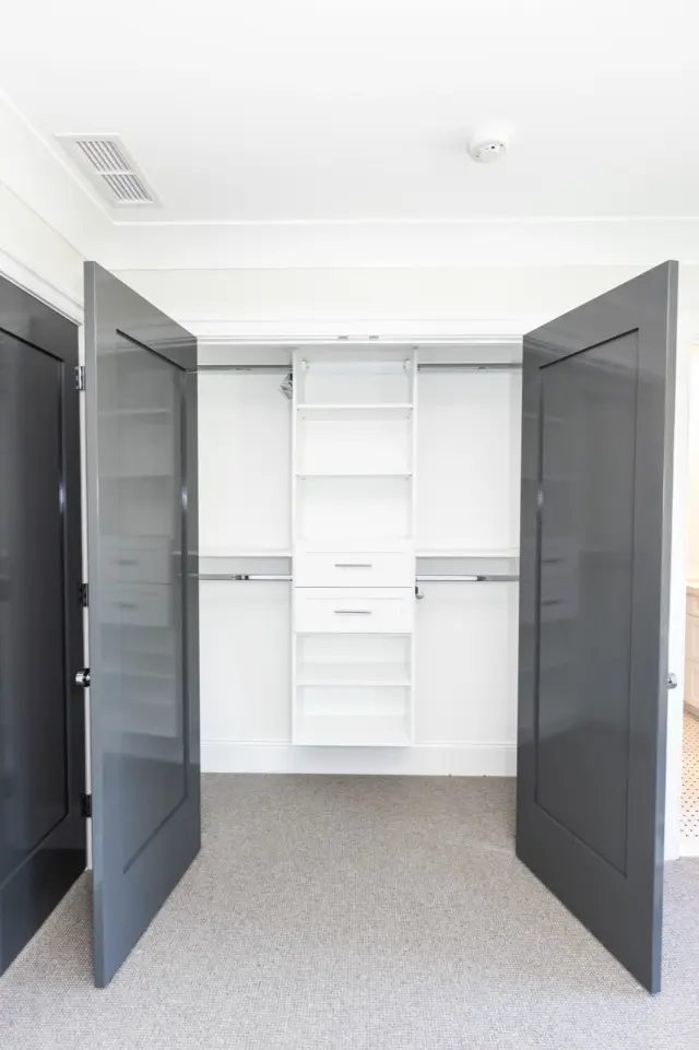 Charcoal doors open to a white shelf tower with drawers and double hanging