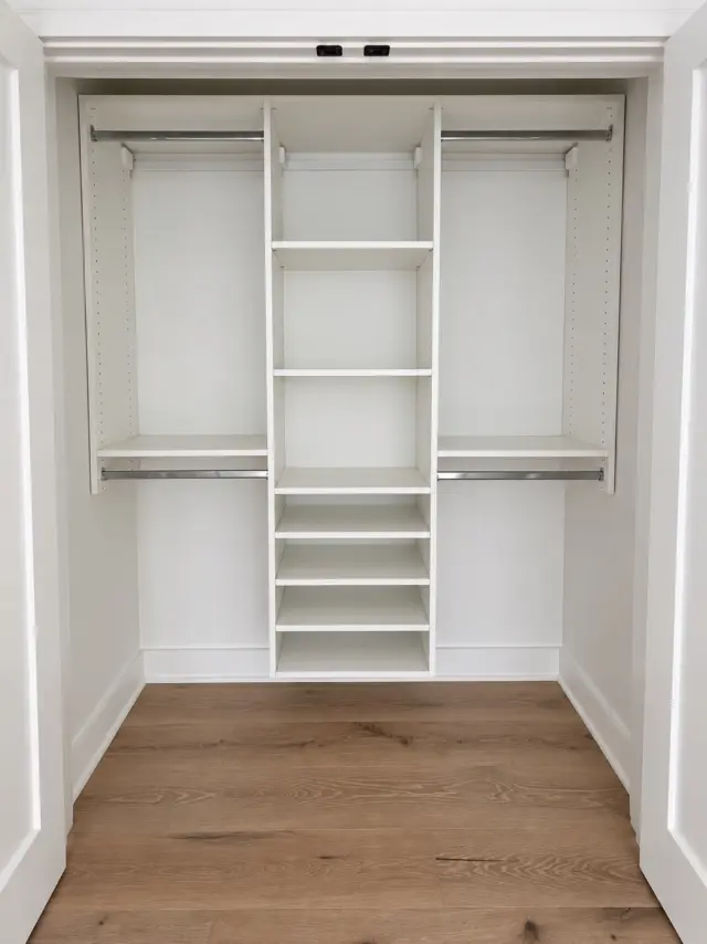Reach-in closet with double hanging on both sides of a center shelf tower
