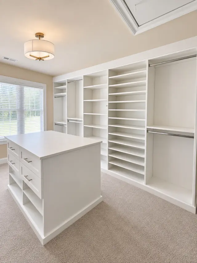 White walk-in closet with an island, shoe shelving and double hanging
