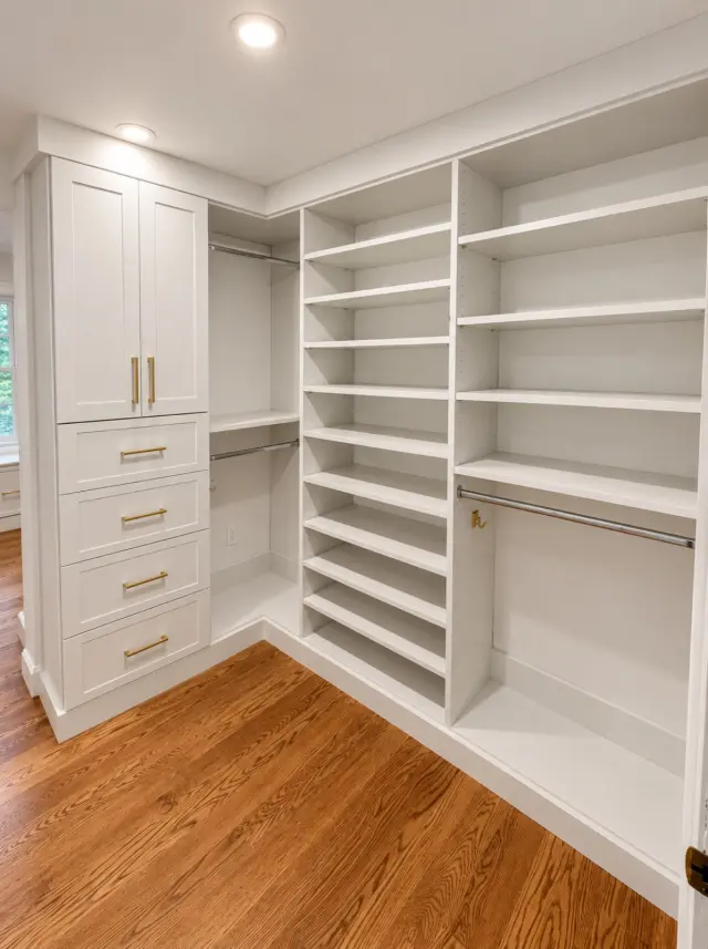 White corner closet with tall cabinets, drawers and hanging