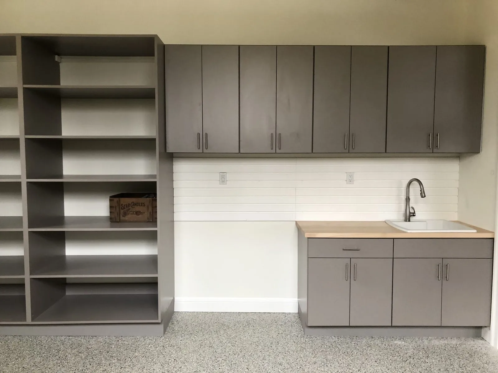 Gray garage cabinets with open shelving and a utility sink