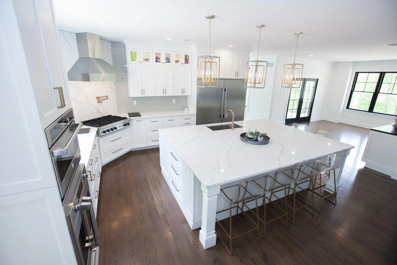 White kitchen with a large island and pendant lights