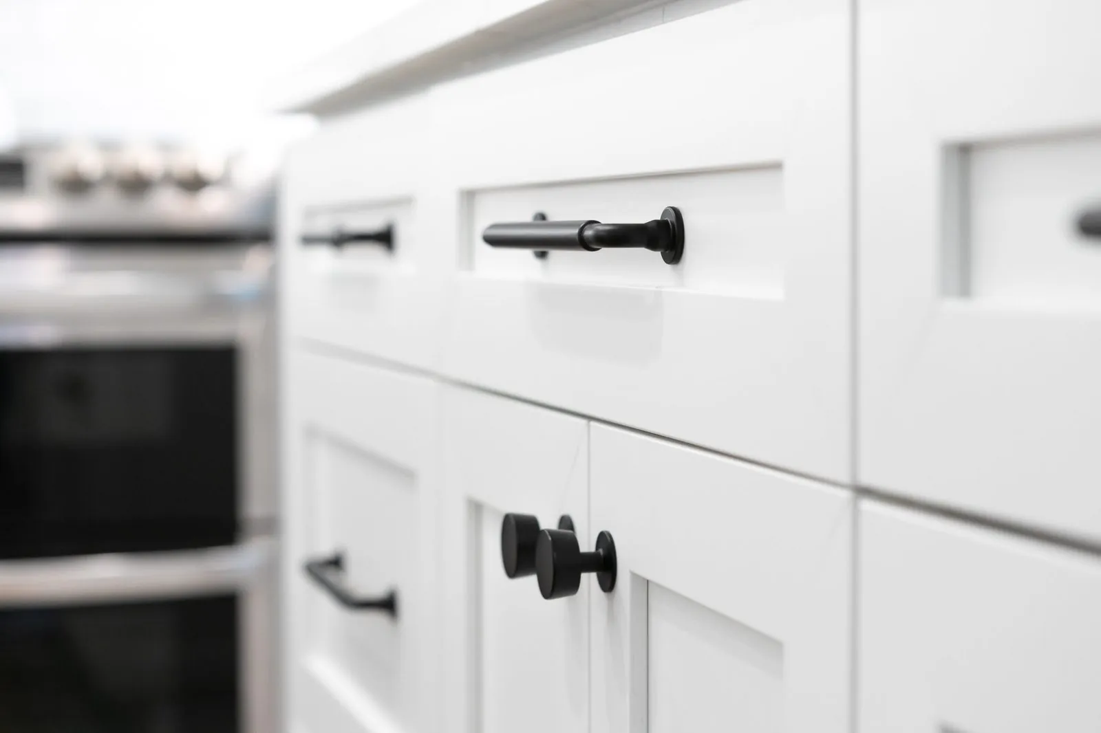 Close-up of white shaker drawers with black pulls