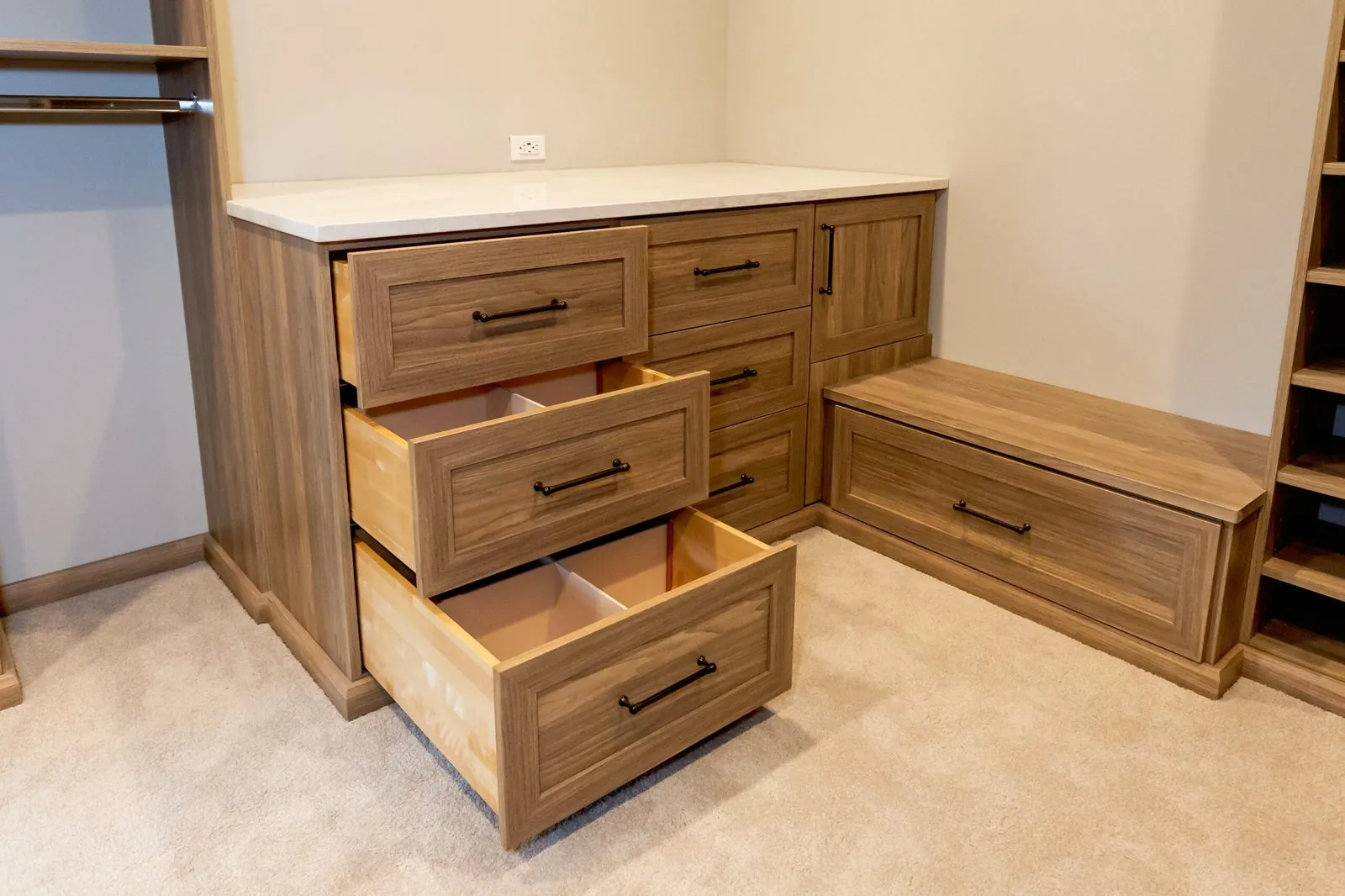 Wood-grain closet drawers pulled open beside a bench