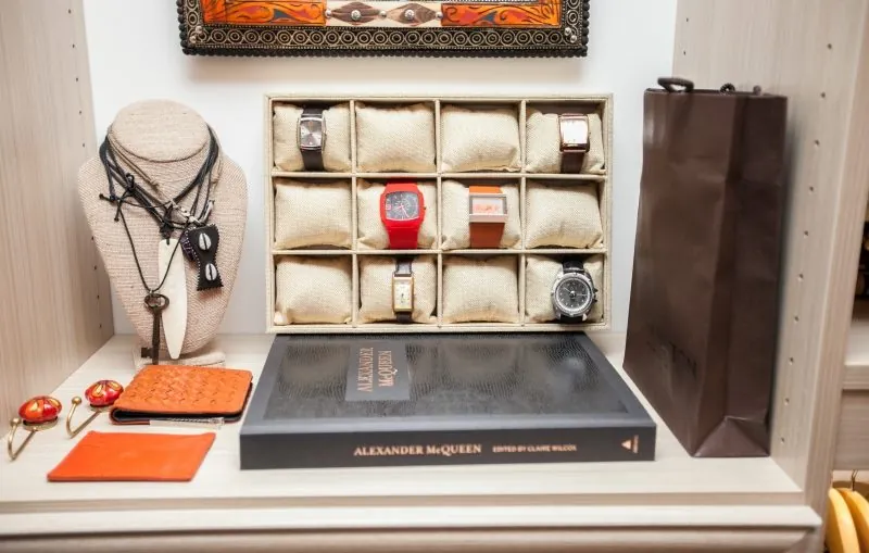 Jewelry and watches displayed on a closet counter with a jewelry tray