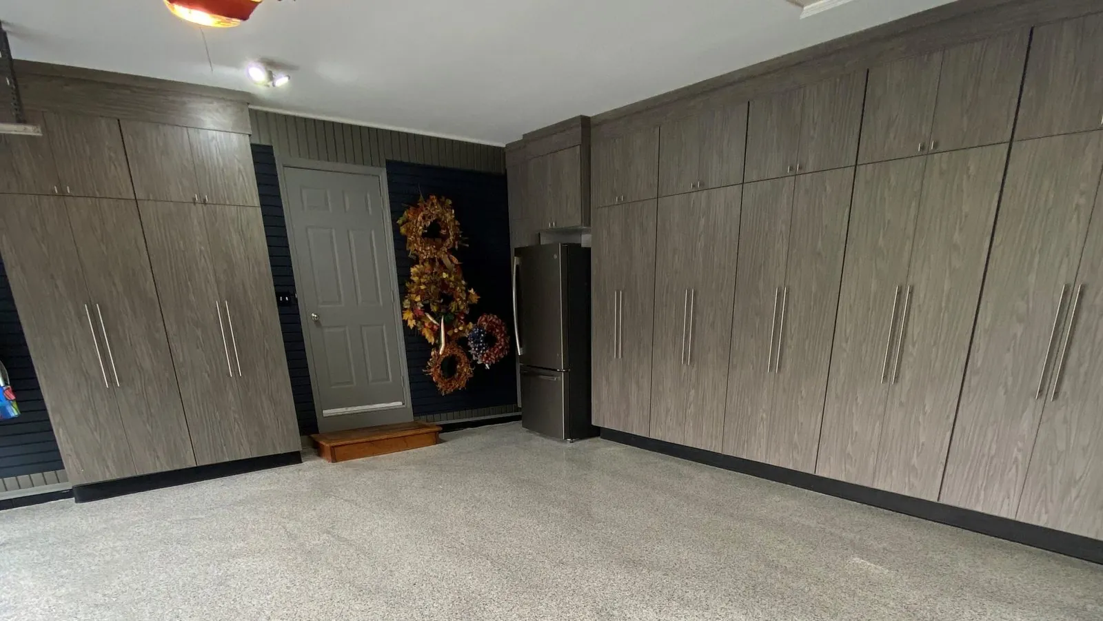 Garage with tall gray wood-grain cabinets along two walls