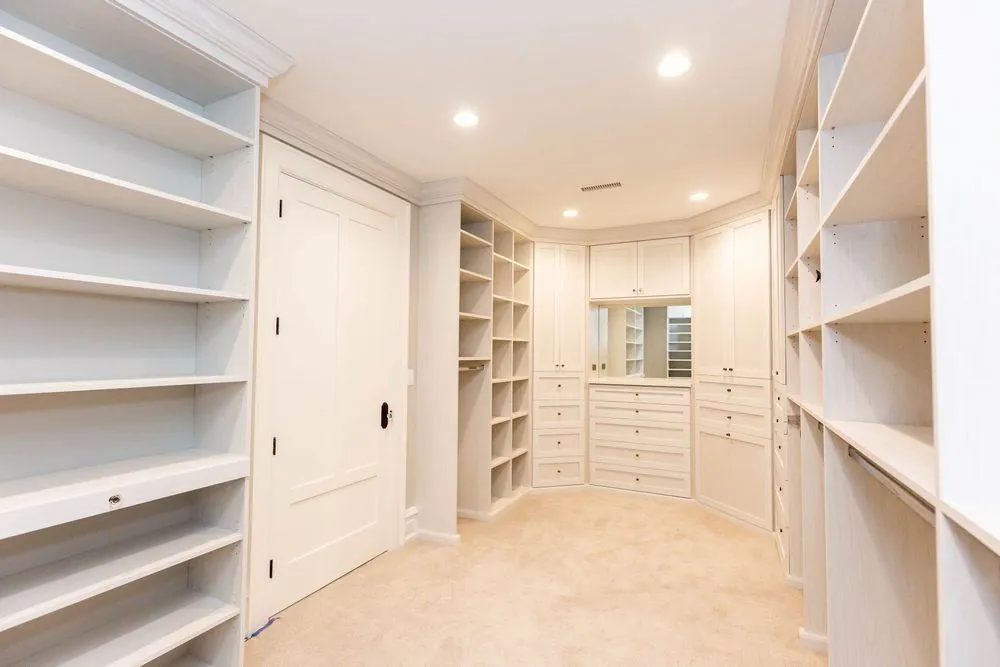 White closet with tall shelving on both walls