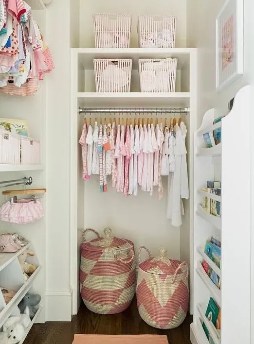 Children's closet with pink clothes, shelves and fabric bins