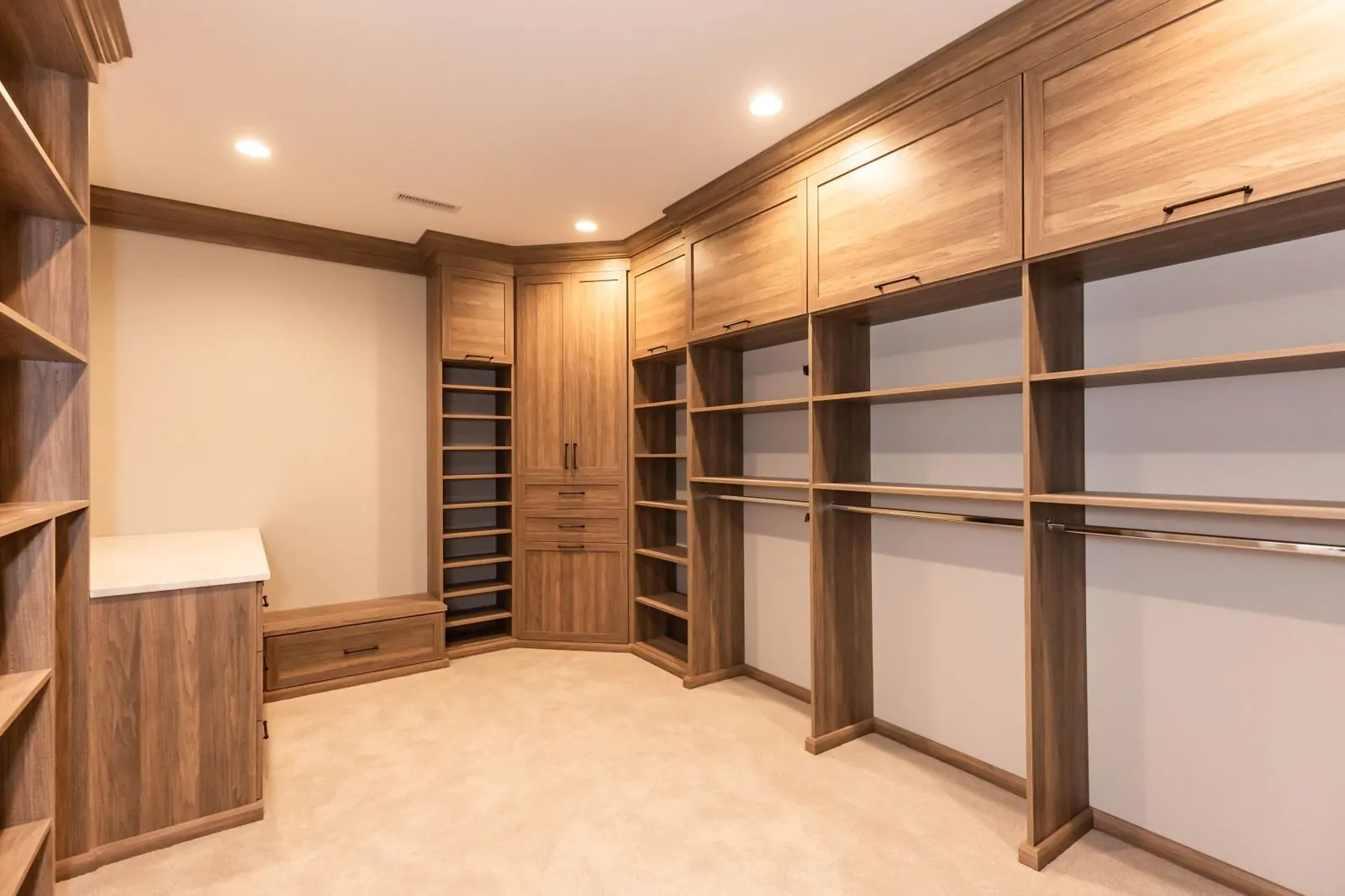 Wood-grain walk-in closet with long hanging, shelves and a corner shoe unit
