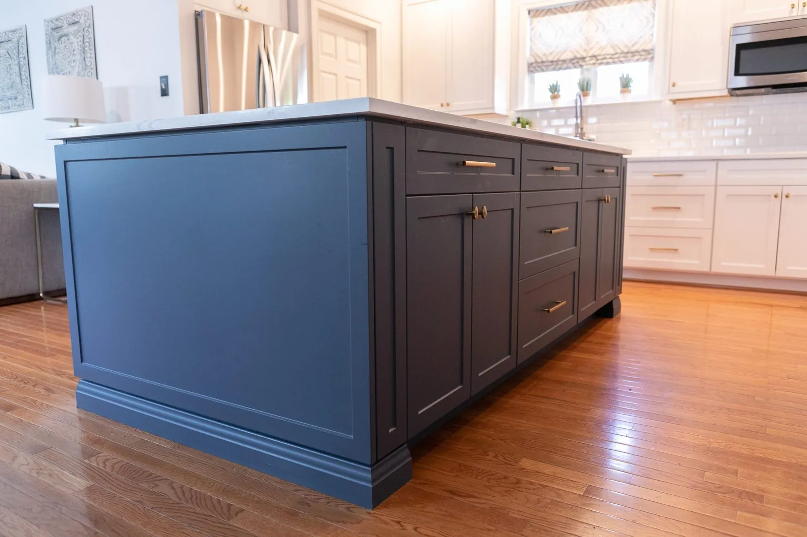 Navy kitchen island with shaker cabinets in a white kitchen