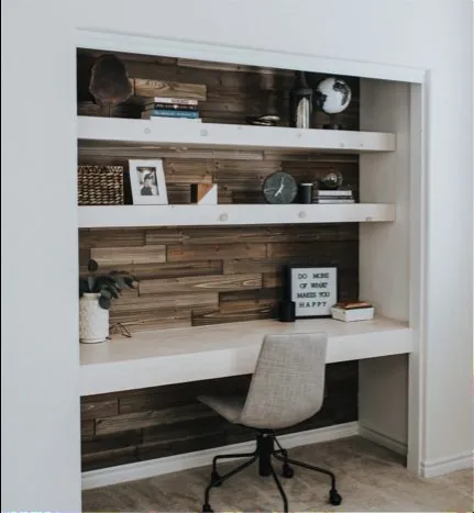 Built-in desk with a reclaimed wood back, open shelves and an office chair