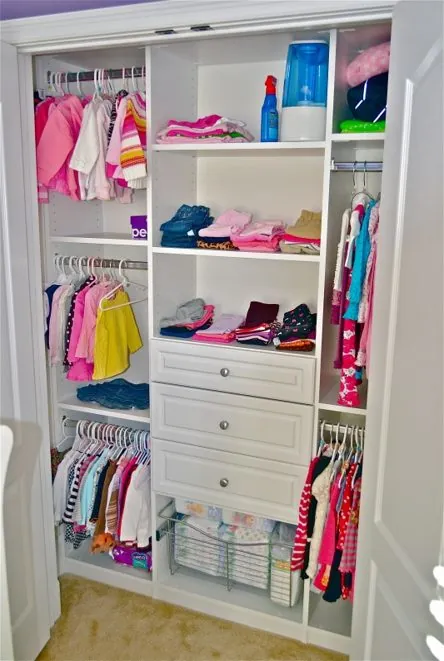 Children's reach-in closet with colorful clothes, shelves and drawers