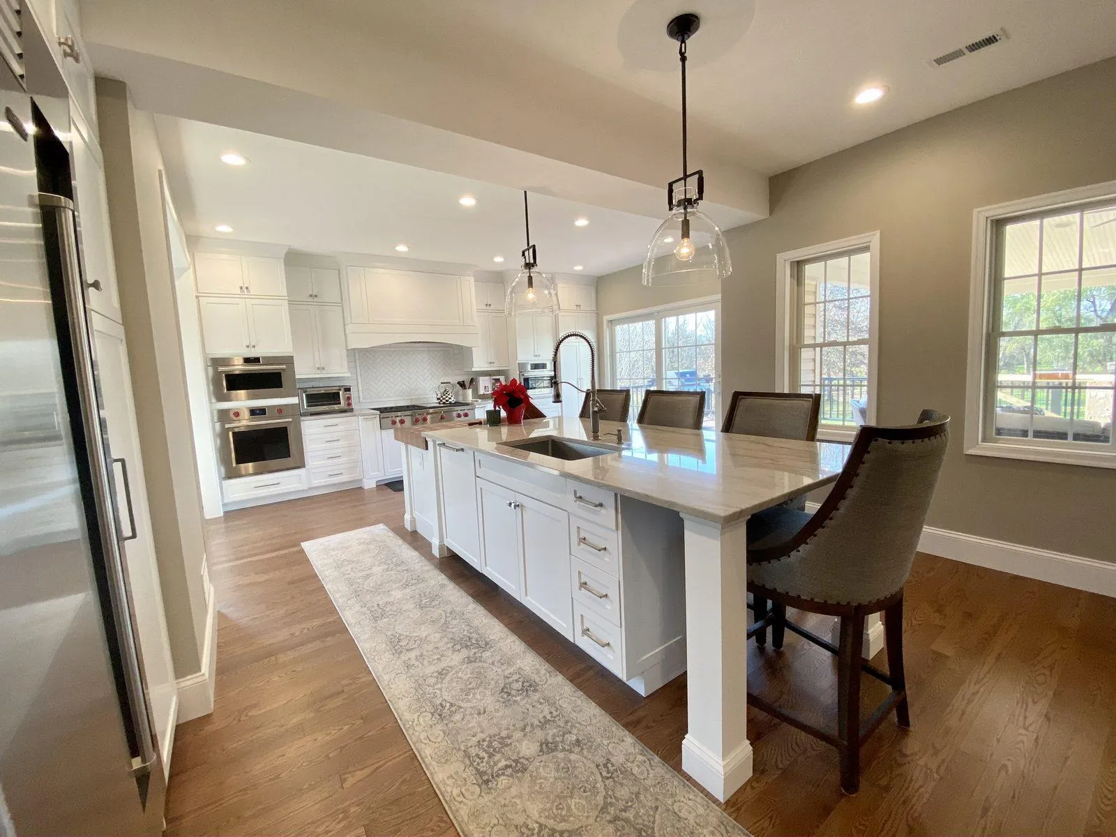 Open kitchen with a long white island and pendant lights