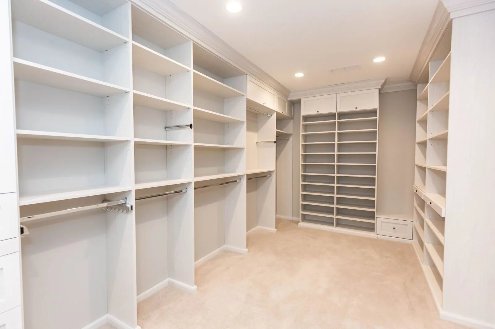 White walk-in closet with shelving and hanging along both walls