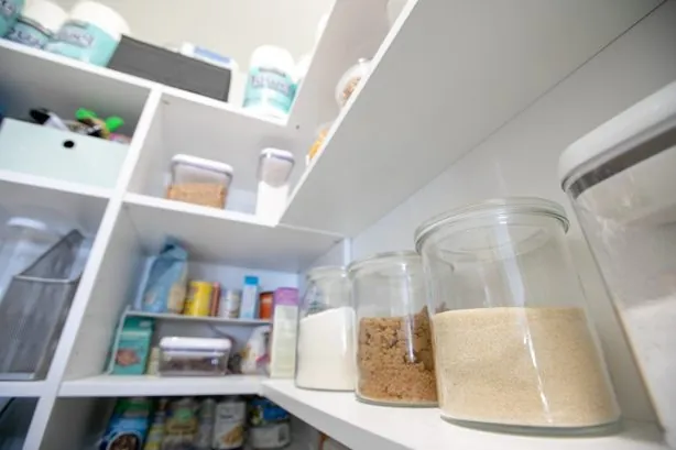 Pantry shelves with glass storage jars and food containers