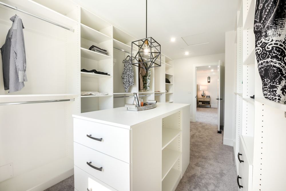 a beautifully staged, custom closet with new built-in storage systems