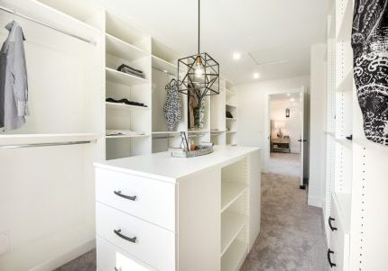 a beautifully staged, custom closet with new built-in storage systems